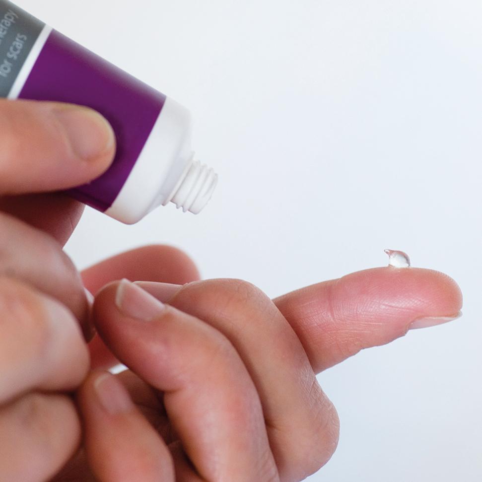 Person applying silicone gel onto a post-surgical scar