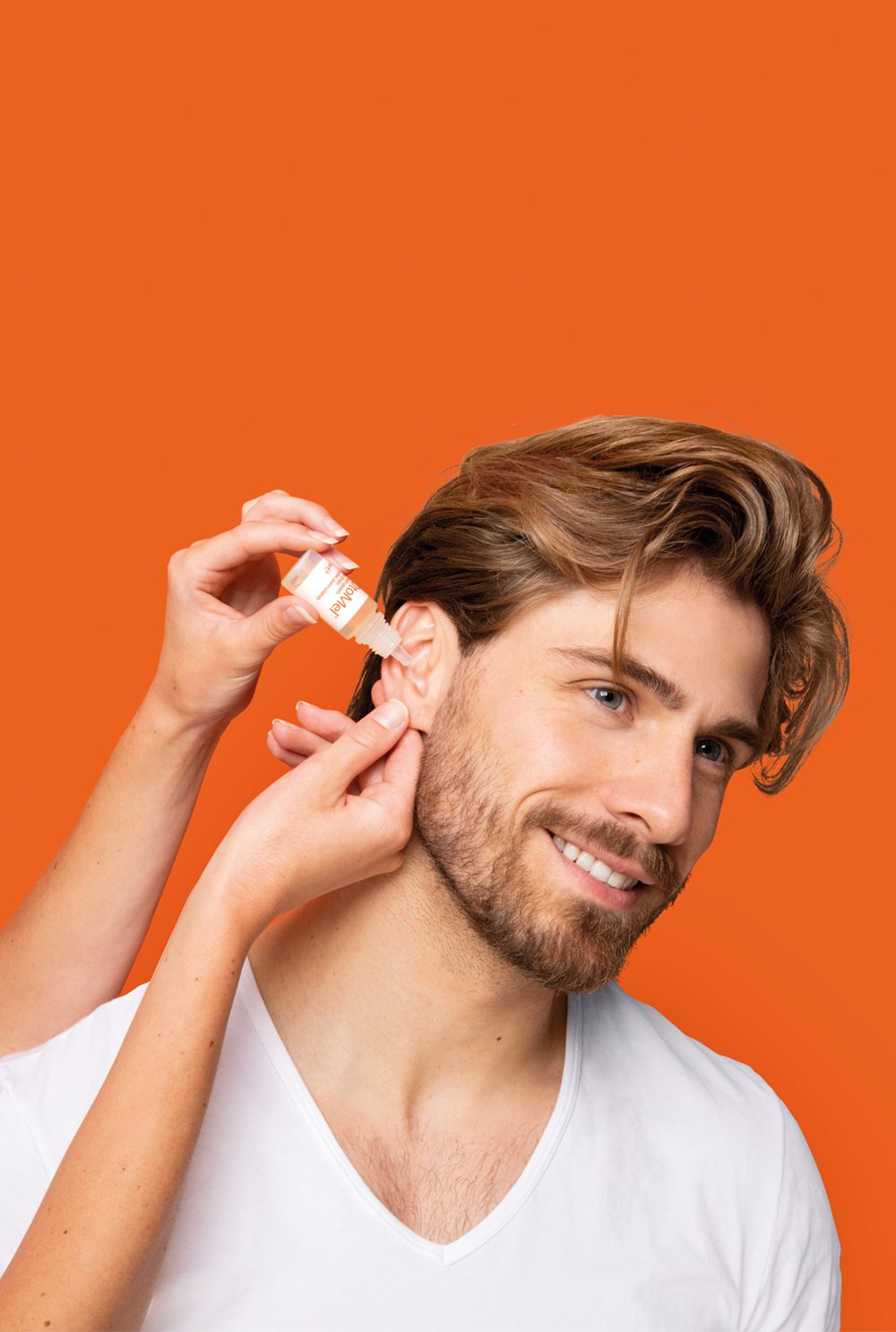 Person applying OhroMel ear drops for ear irritation and discomfort