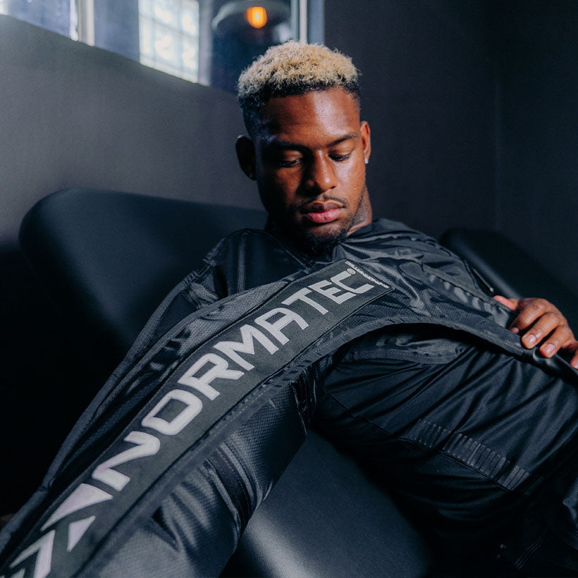 Man showing how to use Normatec arm compression sleeve