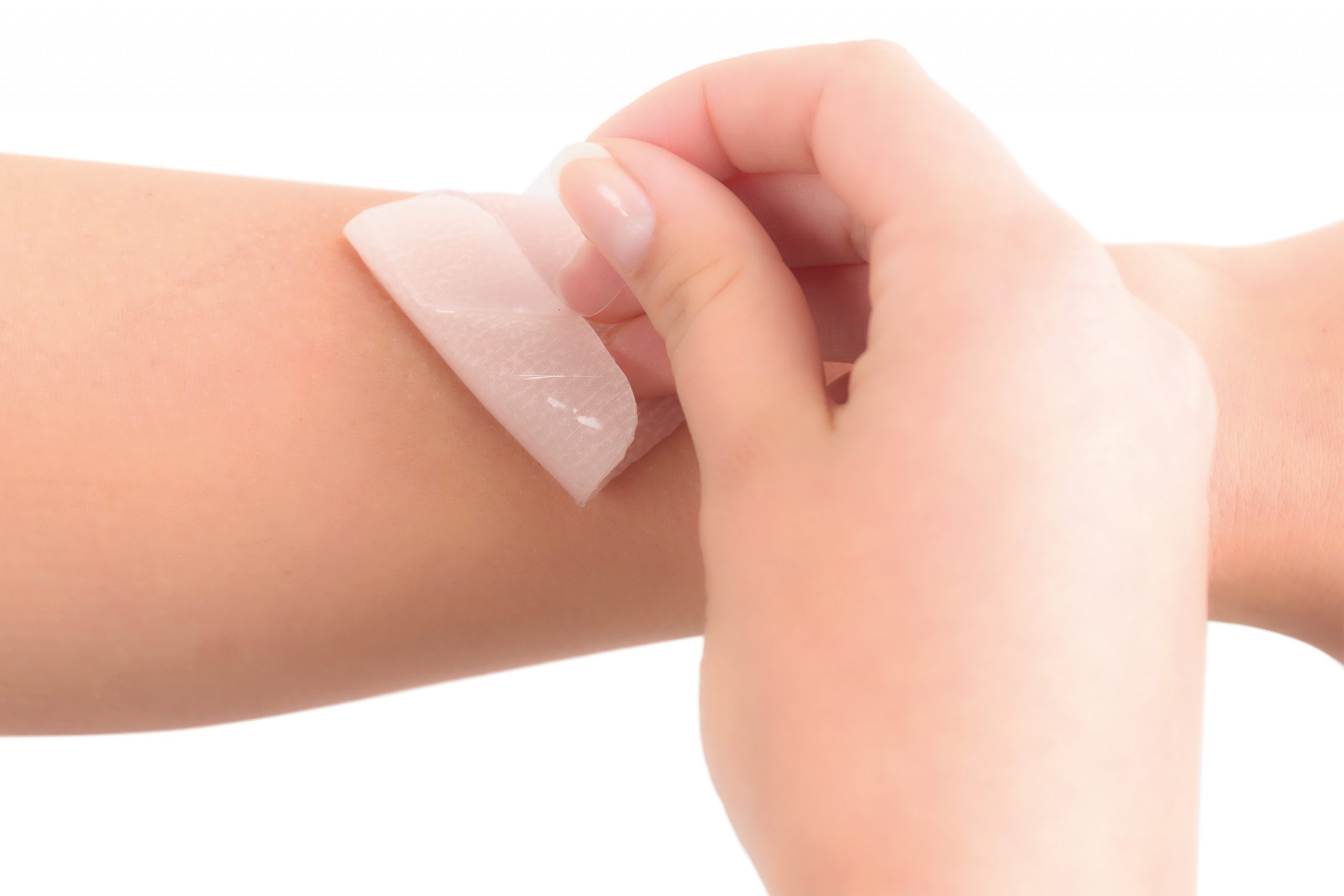 Person applying silicone sheeting to scar on the arm