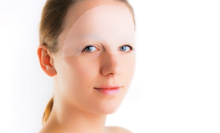 Close-up of Scarban Elastic silicone scar sheet being applied to forehead area to reduce scar redness, thickness, and irritation